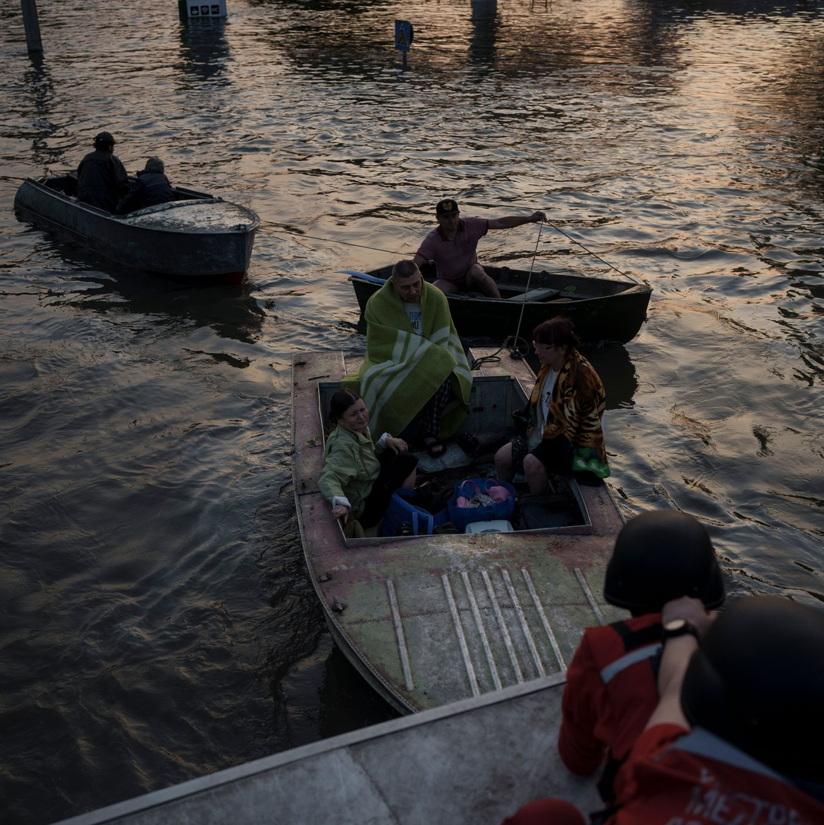 Rettungskräfte versuchen, Boote mit Bewohnern abzuschleppen. - Foto: Felipe Dana/AP/dpa