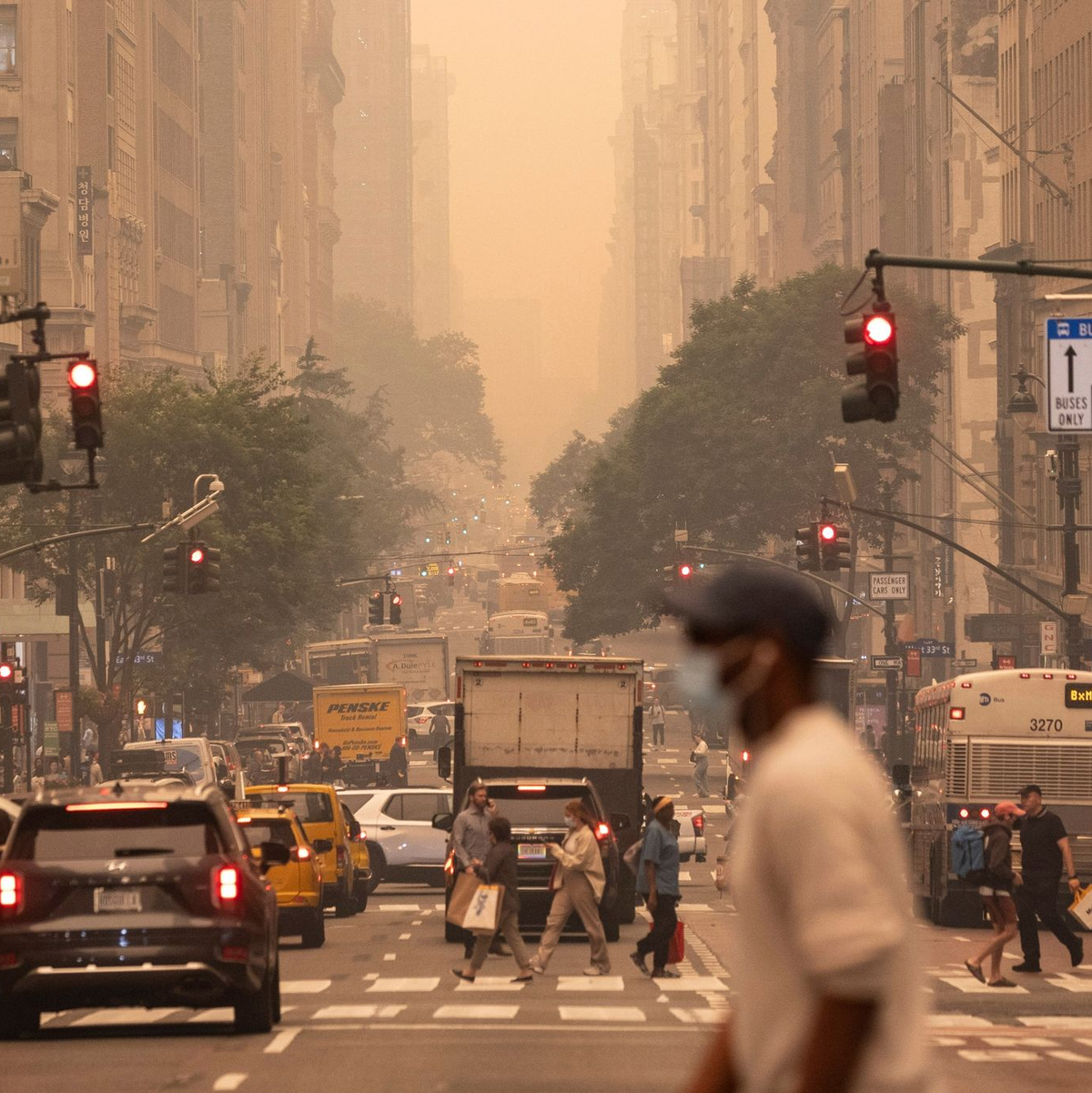 Ein Mann mit FFP2-Maske überquert eine Kreuzung in Manhattan. - Foto: Yuki Iwamura/AP/dpa