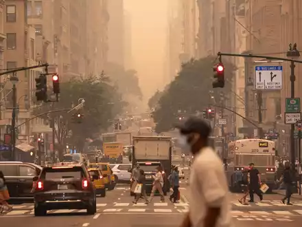 Ein Mann mit FFP2-Maske überquert eine Kreuzung in Manhattan. - Foto: Yuki Iwamura/AP/dpa