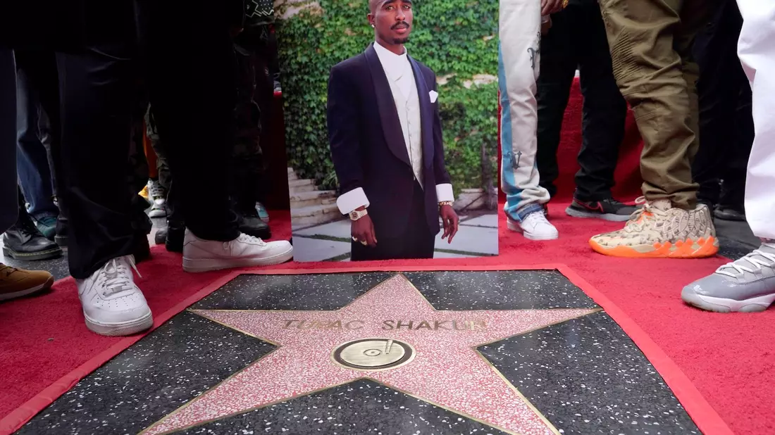 Ein Bild des verstorbenen Rappers und Schauspielers Tupac Shakur steht neben seinem Stern auf dem Hollywood Walk of Fame. - Bild: Chris Pizzello/Invision/AP/dpa