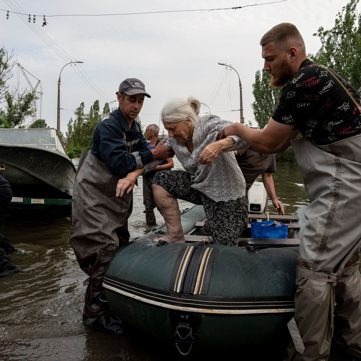 Rettungskräfte evakuieren eine ältere Frau aus einem überfluteten Viertel in Cherson. - Foto: Evgeniy Maloletka/AP