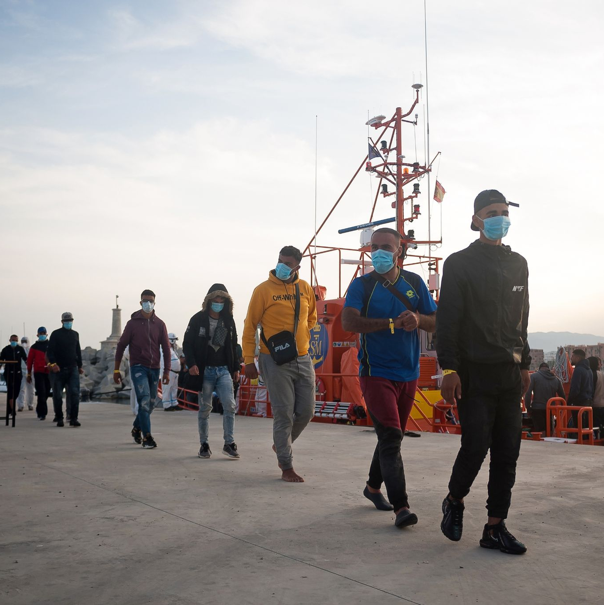 Eine Gruppe maghrebinischer Migranten wartet am Hafen in Malaga, nachdem sie von der spanischen Küstenwache im Mittelmeer gerettet wurde. - Foto: Jesus Merida/SOPA Images via ZUMA Wire/dpa