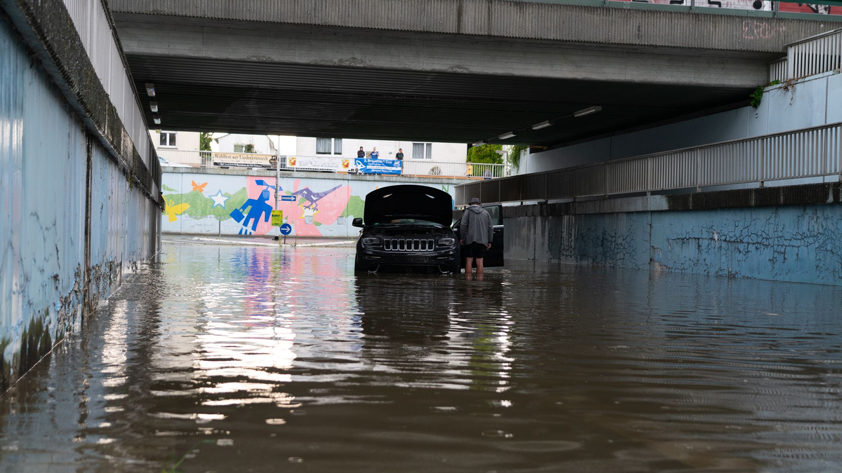 Ein Auto steht in einer überschwemmten Unterführung in Darmstadt. Heftige Gewitter mit Starkregen haben vor allem in Südhessen Schäden angerichtet. - Foto: --/5VISION.NEWS/dpa