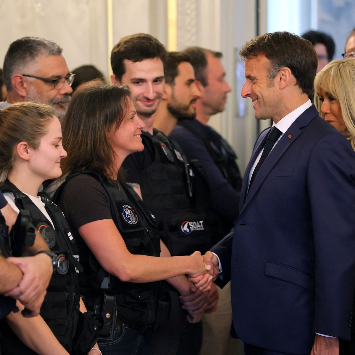 Der französische Präsident Emmanuel Macron und seine Frau Brigitte Macron (r) treffen in Annecy Rettungskräfte. - Foto: Denis Balibouse/Reuters Pool/AP/dpa