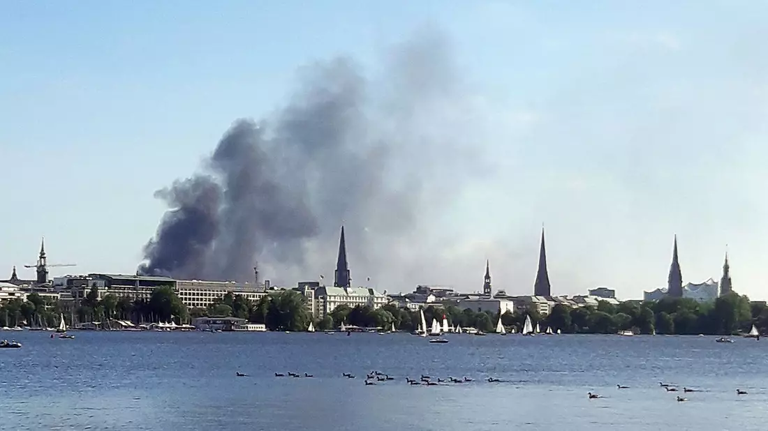 Eine Rauchwolke ist über der Alster in Hamburg zu sehen. Auf einem zehnstöckigen Haus in der Hamburger HafenCity ist es am Freitagnachmittag zu mehreren Explosionen gekommen. - Bild: Désirée Ballhausen/-/dpa