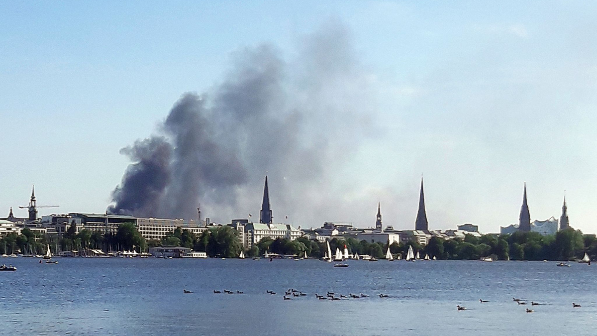 Eine Rauchwolke ist über der Alster in Hamburg zu sehen. Auf einem zehnstöckigen Haus in der Hamburger HafenCity ist es am Freitagnachmittag zu mehreren Explosionen gekommen. - Foto: Désirée Ballhausen/-/dpa