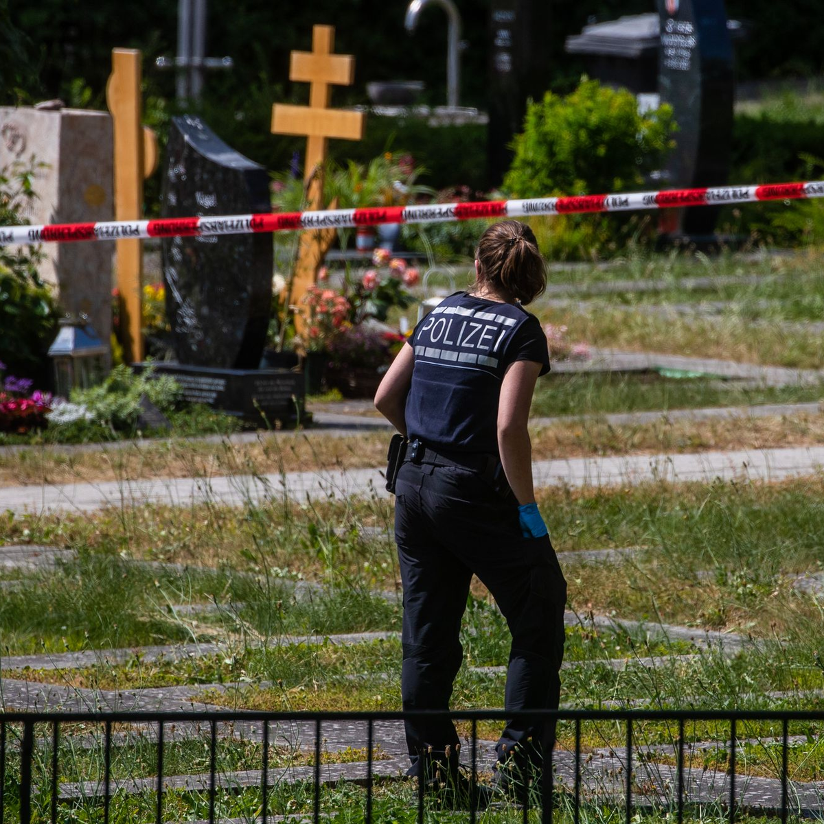Die Polizei am Tatort auf einem Friedhof. - Foto: Christoph Schmidt/dpa