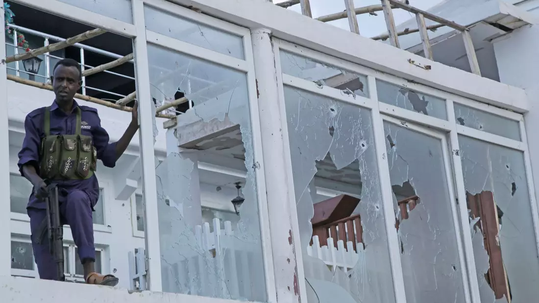 Ein somalischer Soldat steht vor einem zerstörten Fenster des Pearl Beach Hotels in Mogadischu. - Bild: Farah Abdi Warsameh/AP