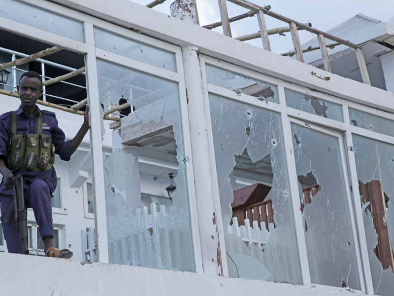 Ein somalischer Soldat steht vor einem zerstörten Fenster des Pearl Beach Hotels in Mogadischu. - Foto: Farah Abdi Warsameh/AP
