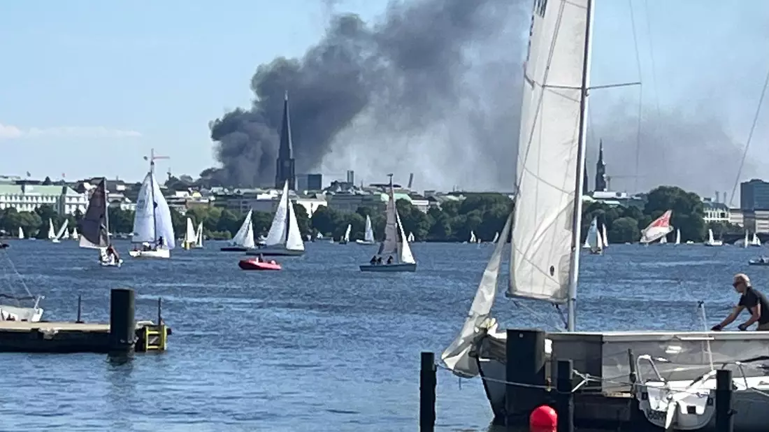 Die Rauchwolke ist über der Alster in Hamburg zu sehen. - Bild: Britta Pedersen/dpa