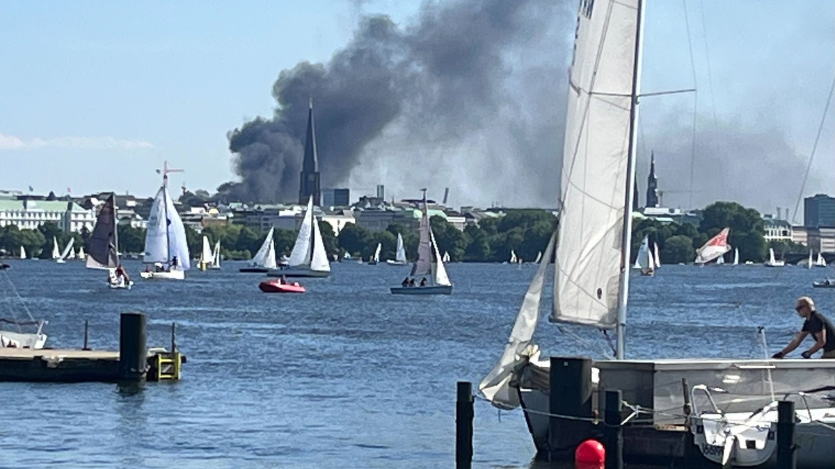 Die Rauchwolke ist über der Alster in Hamburg zu sehen. - Foto: Britta Pedersen/dpa