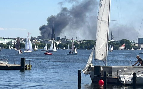 Die Rauchwolke ist über der Alster in Hamburg zu sehen. - Foto: Britta Pedersen/dpa