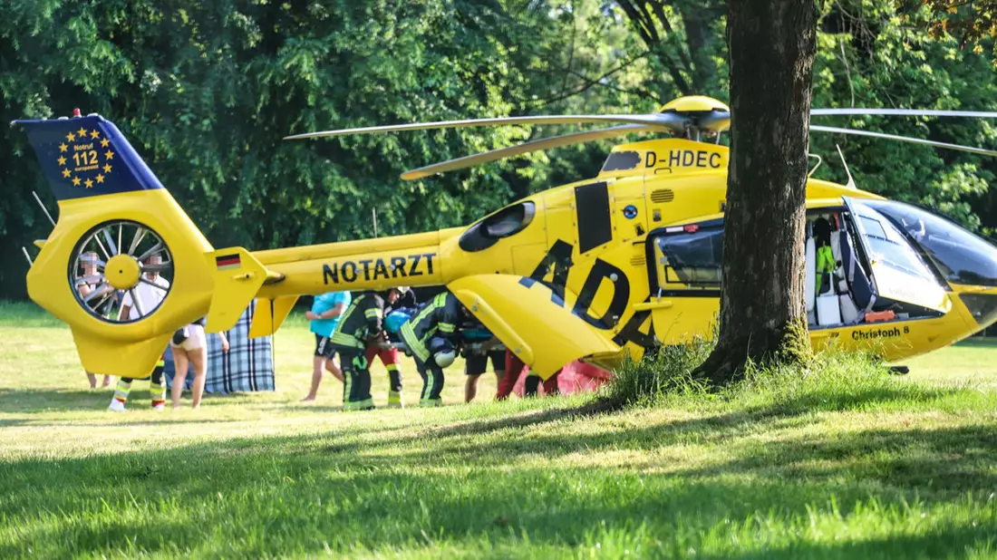 Ein Rettungshubschrauber im Naturbad am See im Einsatz, wo sich ein Kind beim Spielen schwer verletzt hat. - Bild: Alex Talash/dpa