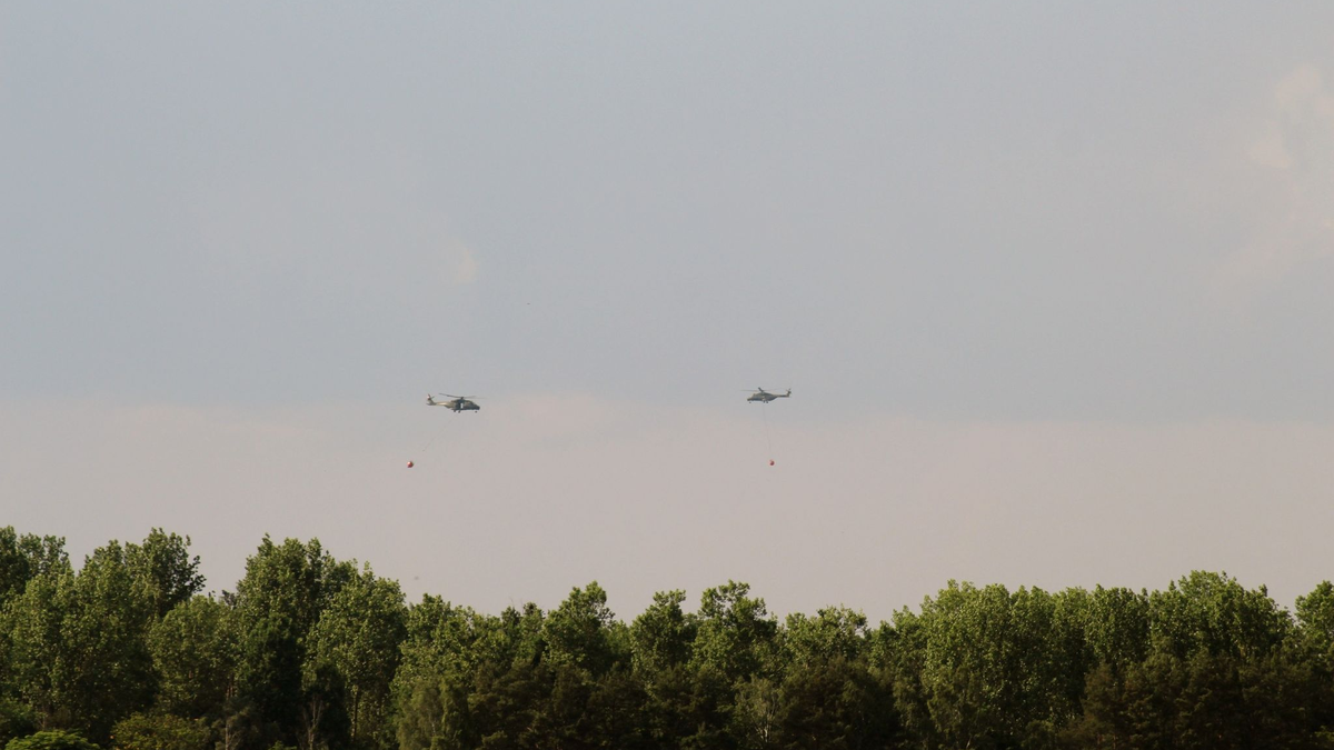 Hubschrauber der Bundeswehr und Bundespolizei überfliegen überfliegen das Waldbrandgebiet Forst Zinna bei Jüterbog und löschen aus der Luft. - Foto: Christian Pörschmann/dpa