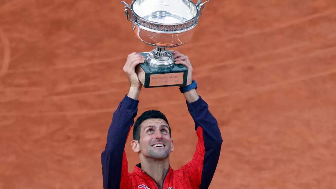 French-Open-Sieger Novak Djokovic reckt die Trophäe in die Höhe. - Bild: Jean-Francois Badias/AP/dpa
