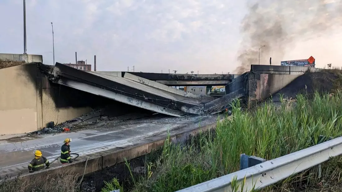Feuerwehrleute stehen in der Nähe des zusammengebrochenen Teils der I-95. - Bild: Uncredited/Philadelphia Fire Department/AP/dpa