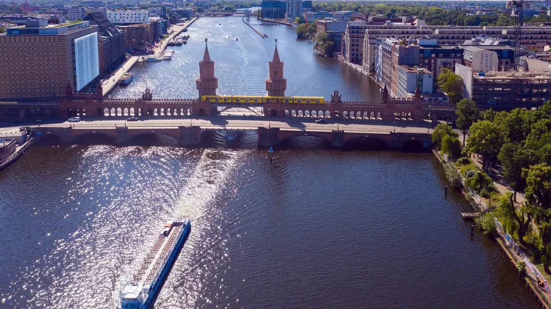 Ein Ausflugsschiff fährt unweit der Oberbaumbrücke auf der Spree in Richtung Berliner Innenstadt. - Bild: Paul Zinken/dpa