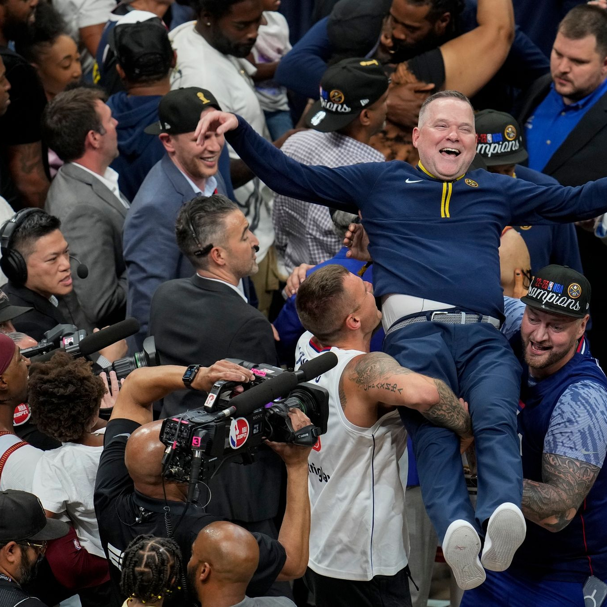Michael Malone, Cheftrainer der Denver Nuggets, wird von den Fans hochgehoben, nachdem das Team die NBA-Meisterschaft gewonnen hat. - Foto: David Zalubowski/AP