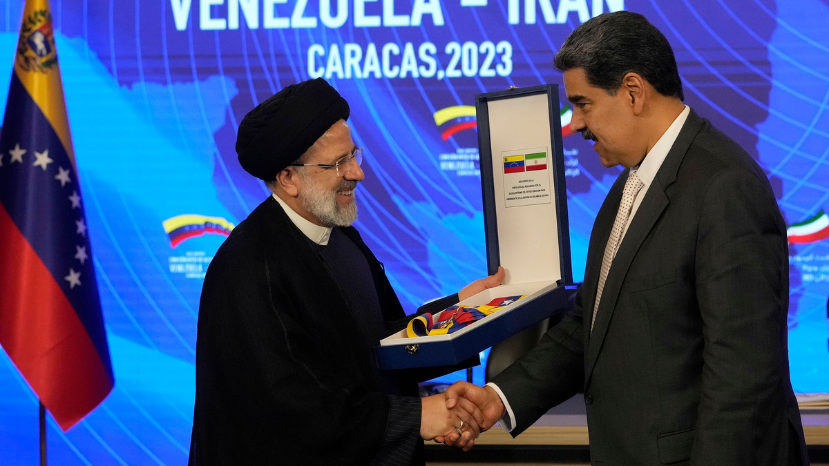 Irans Präsident Ebrahim Raisi (l) gibt Venezuelas Staatsoberhaupt Nicolas Maduro (r) die Hand, als er den Orden 