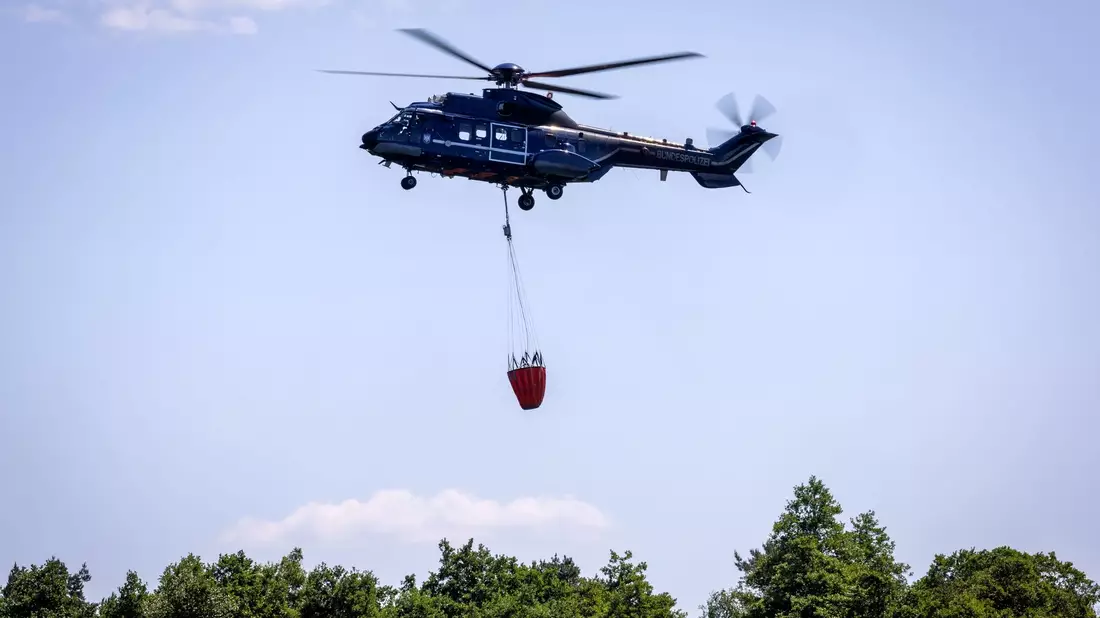 Ein Löschhubschrauber der Bundespolizei im Einsatz. - Bild: Jens Büttner/dpa