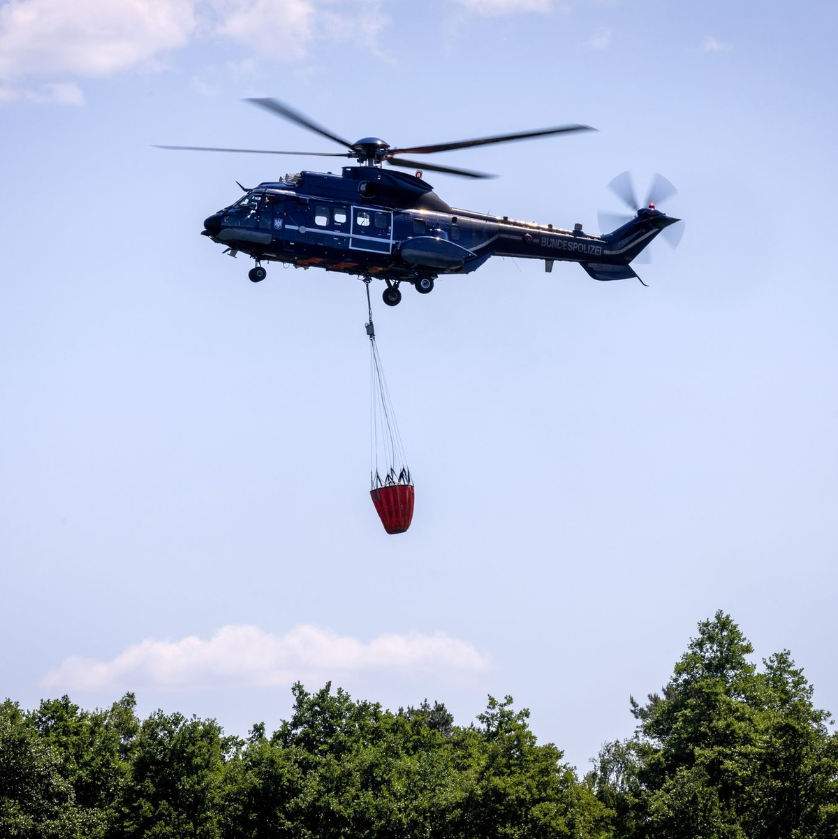 Ein Löschhubschrauber der Bundespolizei im Einsatz. - Foto: Jens Büttner/dpa