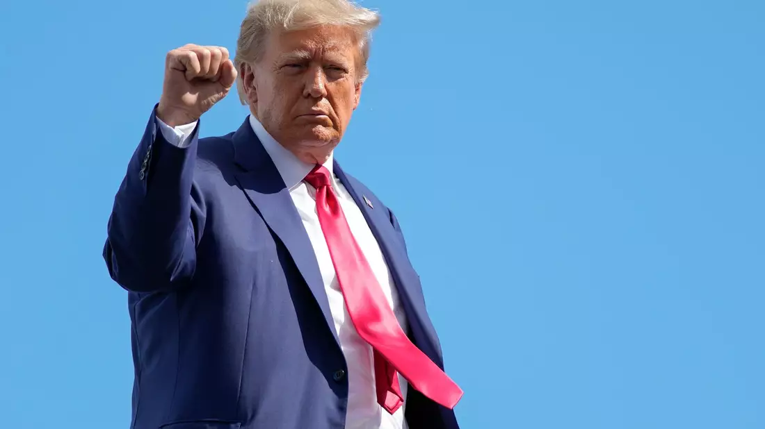 Donald Trump gestikuliert, bevor er sein Privatflugzeug am Miami International Airport besteigt. - Bild: Alex Brandon/AP