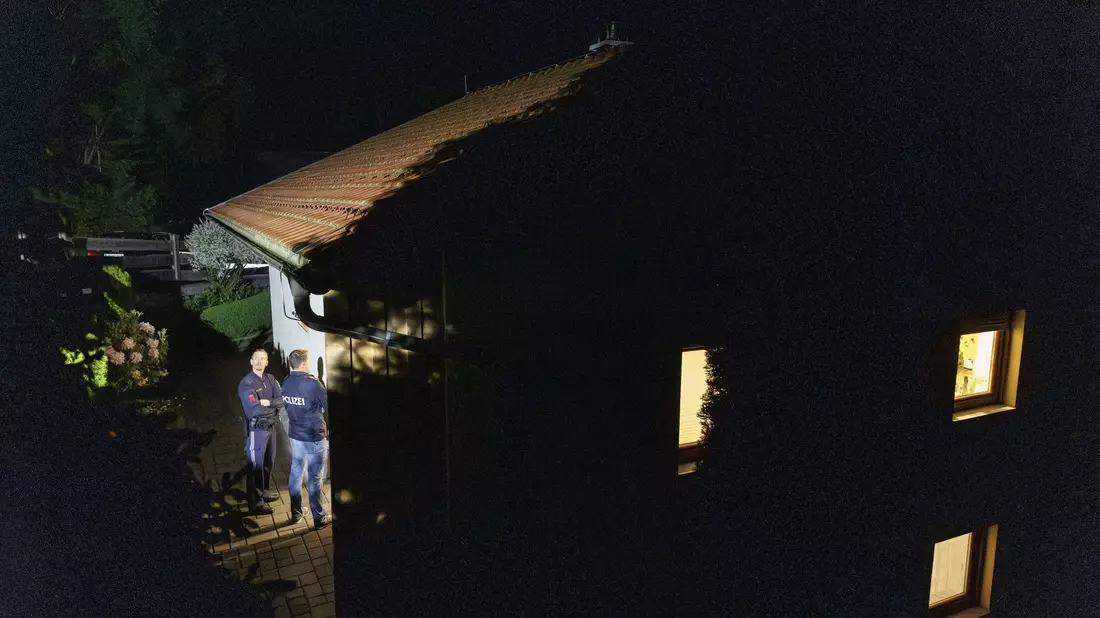 Polizisten stehen während der Ermittlungen vor dem Wohnhaus, in dem drei Leichen gefunden wurden. - Bild: Erwin Scheriau/APA/dpa