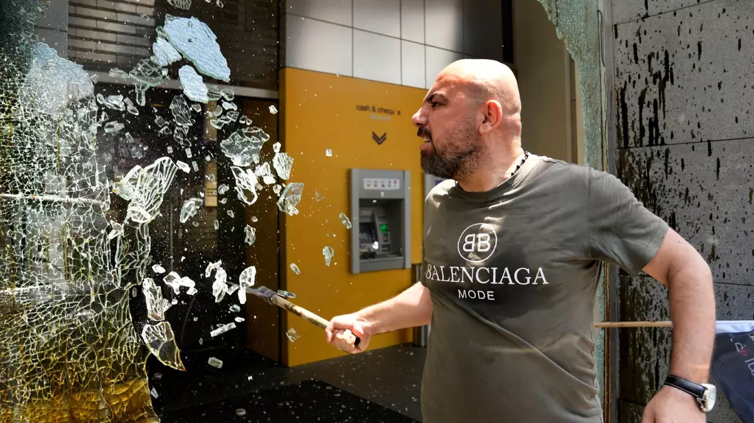 «Die Banken im Libanon stehlen unser Geld!»: Ein Demonstrant zerschlägt Fensterscheiben der Byblos Bank. - Bild: Hussein Malla/AP/dpa
