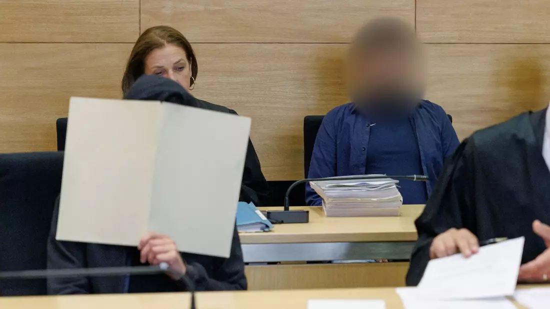 Zwei Angeklagte (vorne l und hinten r) im Gerichtssaal im Landgericht Bielefeld. - Bild: Friso Gentsch/dpa