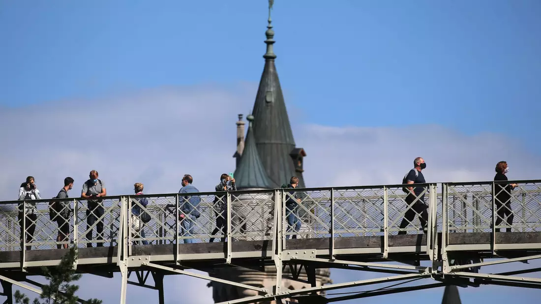 Touristen stehen auf der Marienbrücke vor Schloss Neuschwanstein (Archivbild). In der Nähe des Schlosses hat ein Mann zwei Frauen angegriffen und verletzt. Eine der Frauen starb. - Bild: Karl-Josef Hildenbrand/dpa