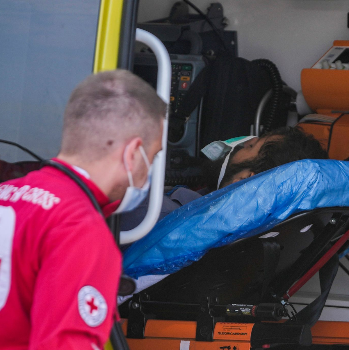 Ein Sanitäter steht im Hafen von Kalamata neben einem verletzten Überlebenden des Schiffsunglücks. - Foto: Thanassis Stavrakis/AP/dpa