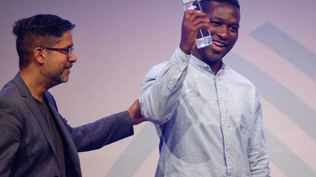 Steve Hiobi (r) und Laudator Hasnain Kazim stehen bei der Verleihung des Grimme Online Award 2023 mit dem Preis für Dein Bruder Steve in der Kategorie Information auf der Bühne. - Bild: Henning Kaiser/dpa