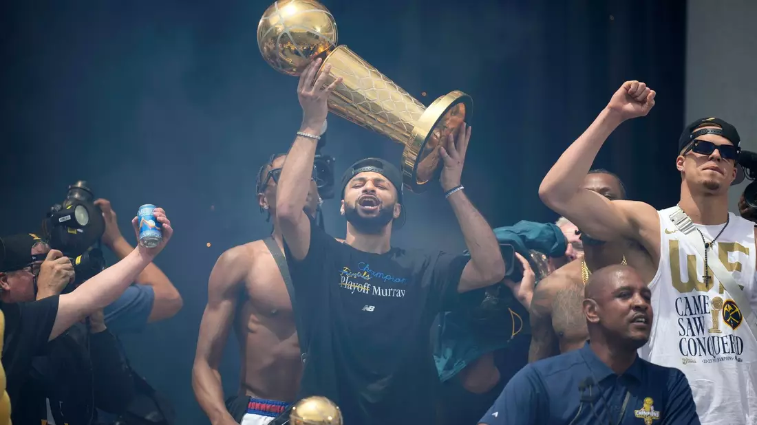 Denver Nuggets-Guard Jamal Murray hält den Pokal. - Bild: David Zalubowski/AP/dpa