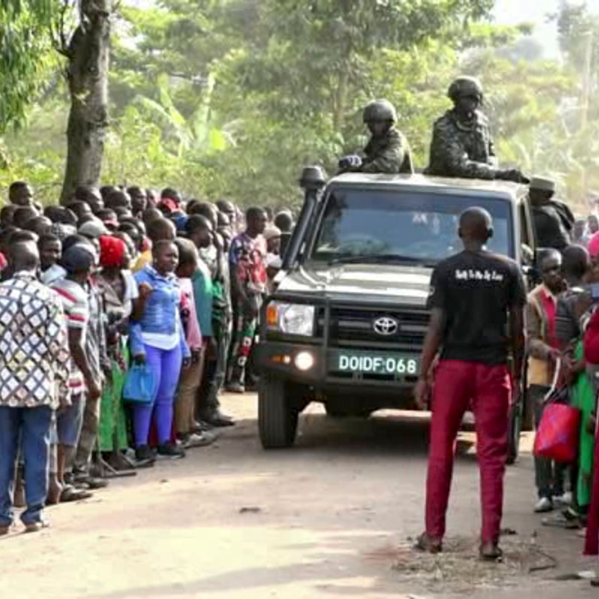 Ugandische Sicherheitskräfte fahren an einer Menschenmenge vorbei, die sich nach dem Angriff vor der Schule in Mpondwe versammelt hat (Videostandbild). - Foto: Uncredited/AP/dpa
