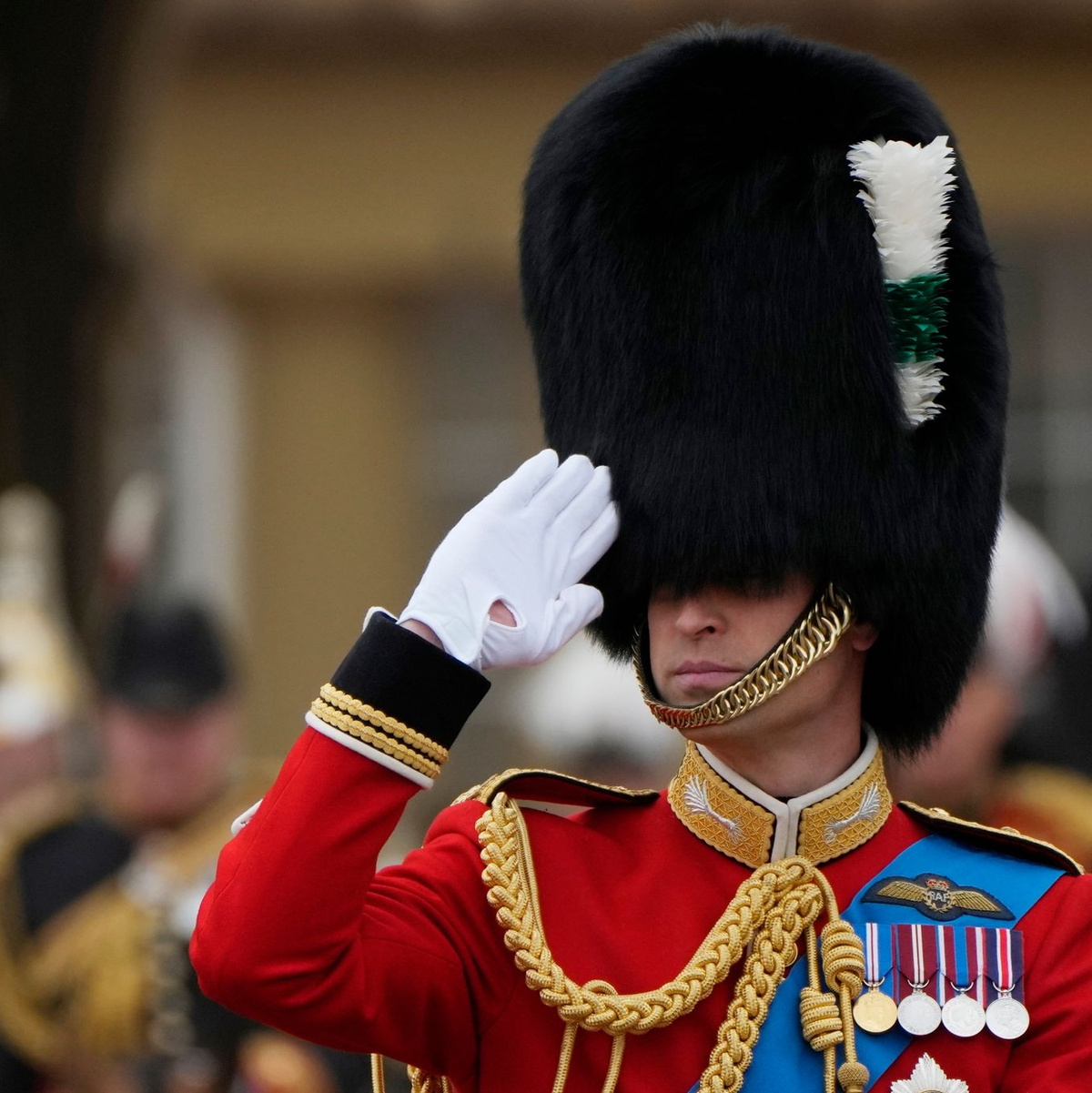 Thronfolger Prinz William trägt Bärenfellmütze und salutiert. - Foto: Alastair Grant/AP/dpa
