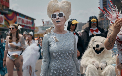 Feiernde grüßen von einem Festwagen. - Foto: Andres Kudacki/AP/dpa