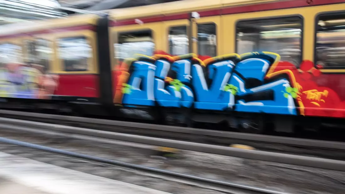 Eine mit Graffiti besprühte S-Bahn fährt aus dem Berliner Ostbahnhof. - Bild: Paul Zinken/dpa