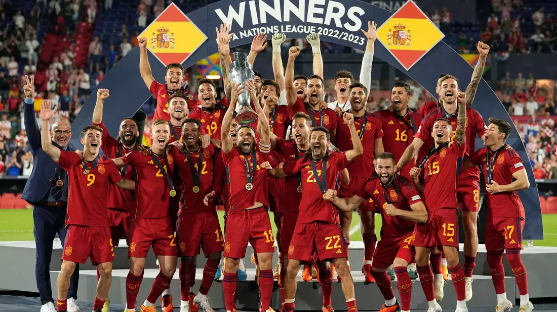 Spaniens Spieler feiern mit der Trophäe nach dem Sieg. - Bild: Martin Meissner/AP