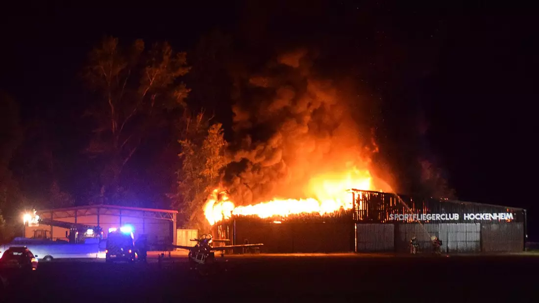 Einsatzkräfte der Feuerwehr löschen den Brand einer Lagerhalle. - Bild: Marco Priebe/PR-Video/dpa