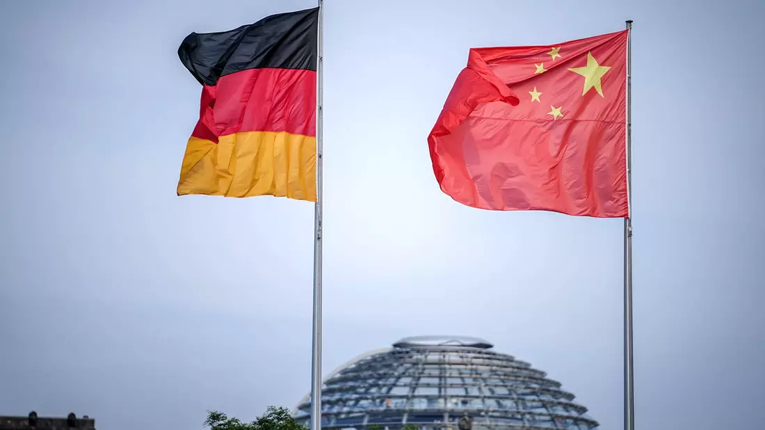 Die Flaggen von Deutschland und China wehen vor dem Bundeskanzleramt. Im Hintergrund die Kuppel des Reichstagsgebäudes. - Bild: Kay Nietfeld/dpa