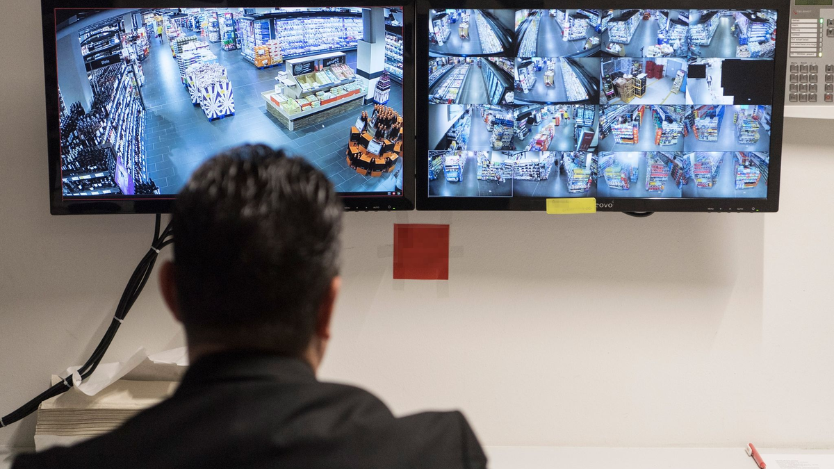 Ein Ladendetektiv sitzt vor den Überwachungsmonitoren eines Supermarktes. - Foto: Boris Roessler/dpa