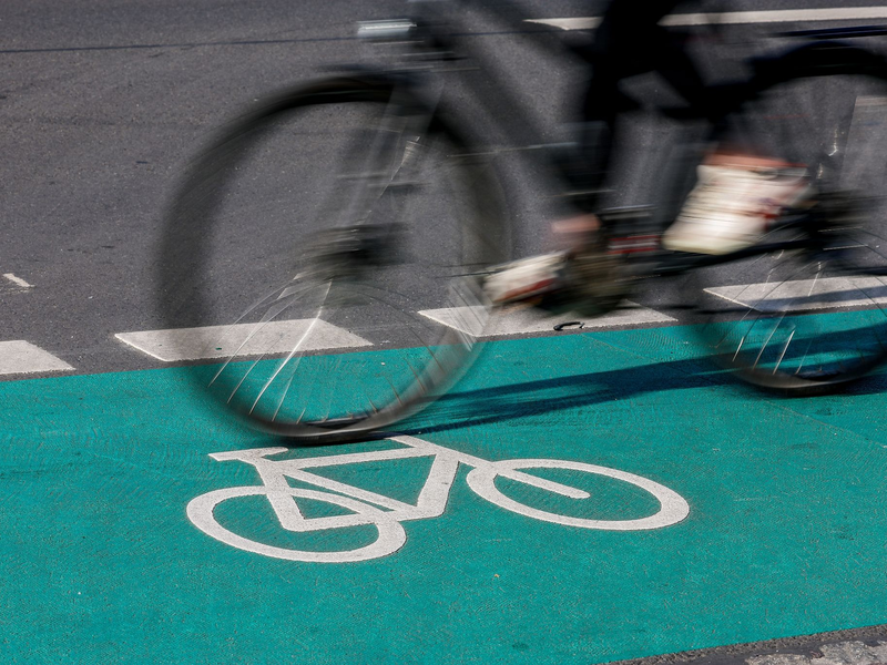 Eine Radfahrerin fährt in Leipzig über einen grün eingefärbten Radweg. - Foto: Jan Woitas/dpa