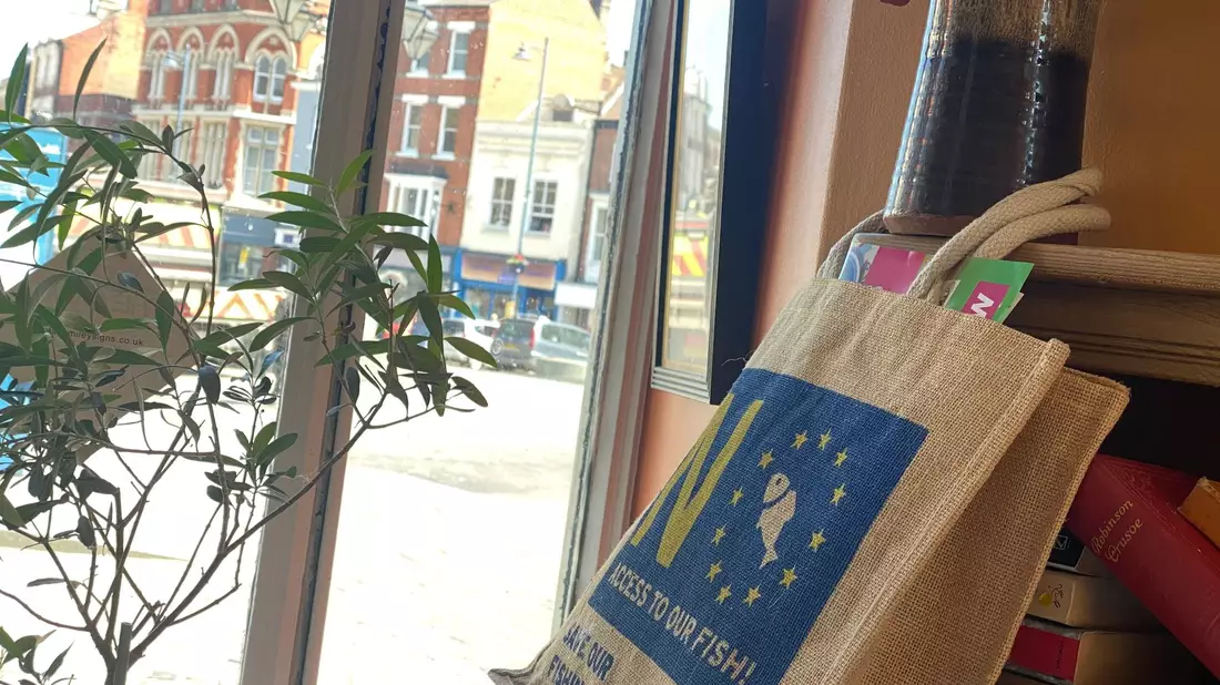 Im Café von Ex-Bürgermeister Anton Dani hängt eine Tragetasche mit einer Anti-EU-Botschaft. - Bild: Benedikt von Imhoff/dpa