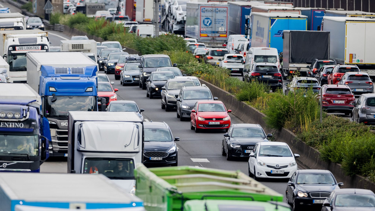 Autos und Lkw stauen sich auf der A3 im Autobahndreieck Köln-Heumar. Nach dem letzten Schultag vor den Sommerferien fahren viele Familien in den Sommerurlaub. - Foto: Rolf Vennenbernd/dpa