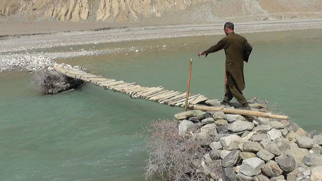 Ein Mann geht über eine hölzerne Brücke im Norden Pakistans nahe der afghanischen Grenze. Sturzfluten im hatten im vergangenen Jahr eine Brücke weggespült. - Bild: Hammad Farooqi/dpa