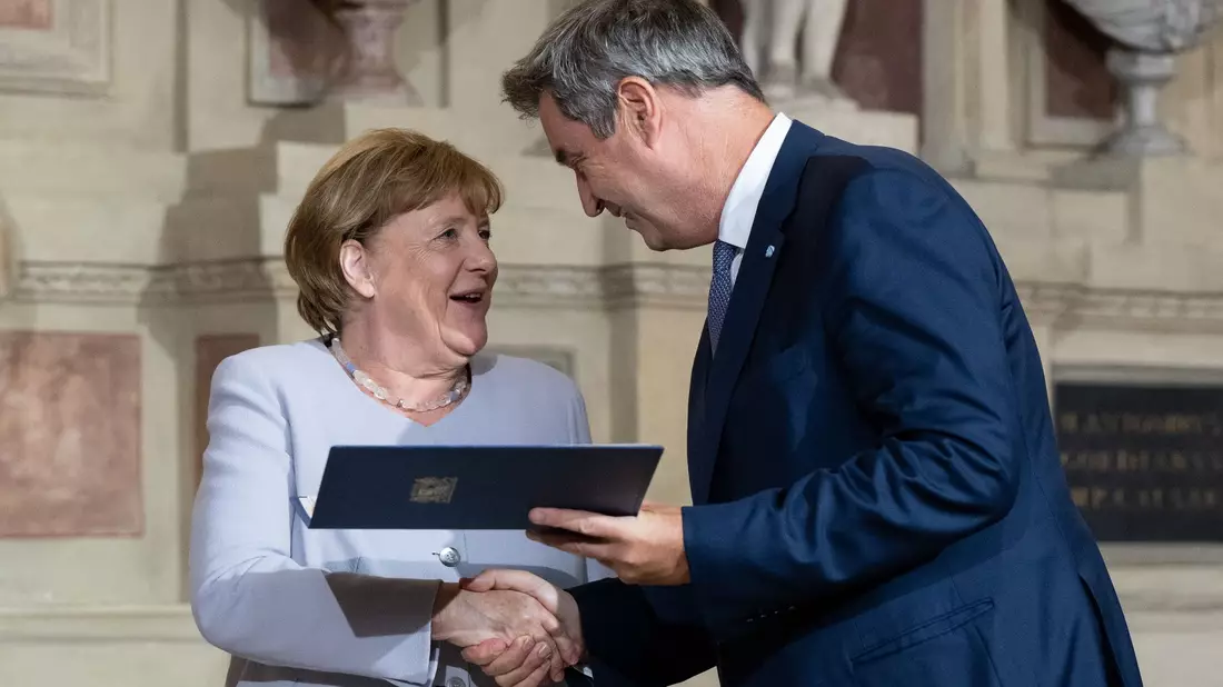 Markus Söder (CSU), Ministerpräsident von Bayern, verleiht Angela Merkel (CDU) den Bayerischen Verdienstorden. - Bild: Sven Hoppe/dpa