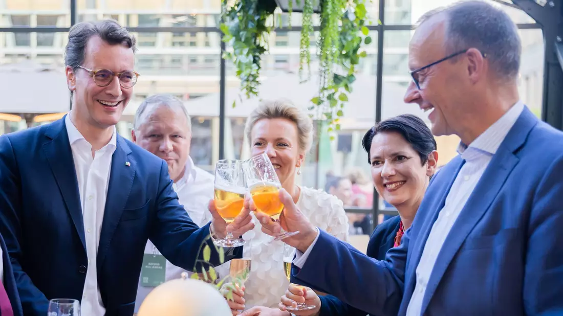 Prost: NRW-Ministerpräsident Hendrik Wüst (l) und CDU-Chef Friedrich Merz stoßen mit einem Bier an. - Bild: Christoph Soeder/dpa