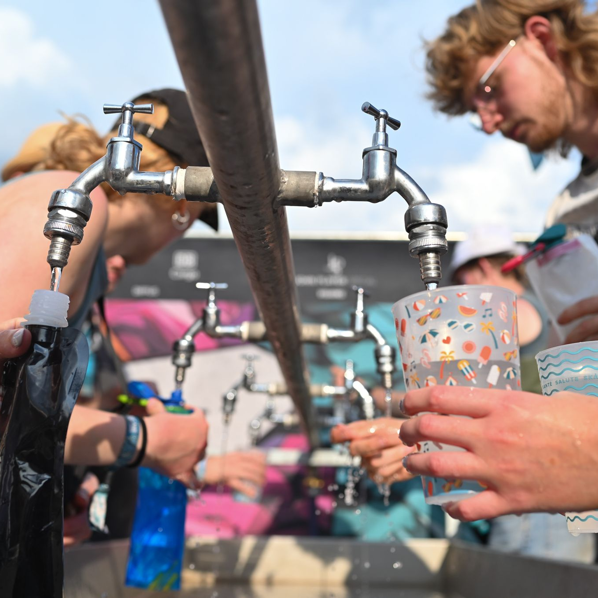 Besucher füllen beim Hurricane Festival ihre Becher und Trinkflaschen mit Wasser auf. In Deutschland steigen die Temperaturen - und die Ozon-Werte. - Foto: Lars Penning/dpa