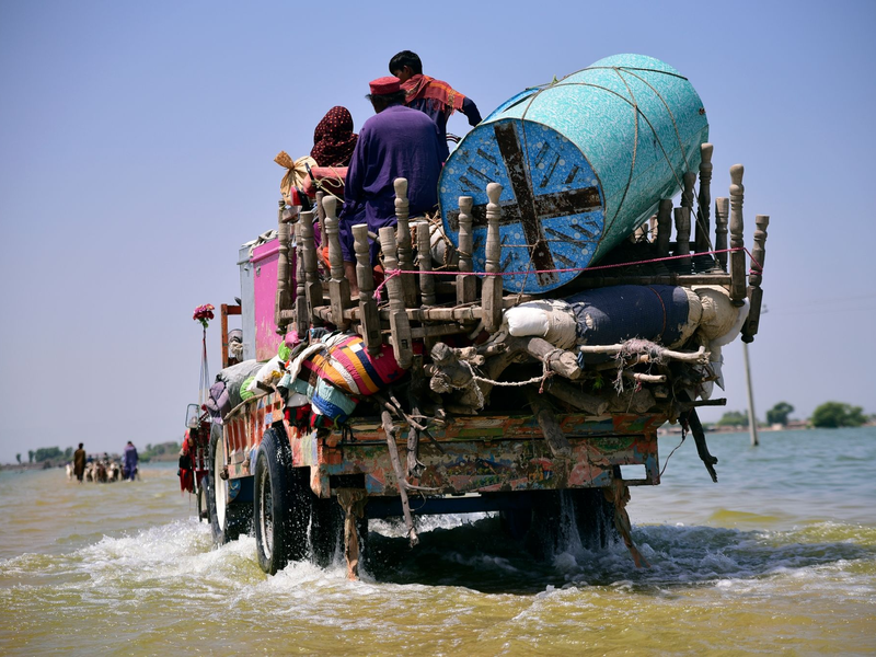Opfer von Überschwemmungen durch schweren Monsunregen bringen Habseligkeiten aus ihrem überfluteten Haus in der pakistanischen Provinz Sindh (Archivbild). Die Teilnehmer der Konferenz haben betont, dass es darum gehe, Armut und Hunger zu bekämpfen und den Klimawandel aufzuhalten. - Foto: Pervez Masih/AP/dpa