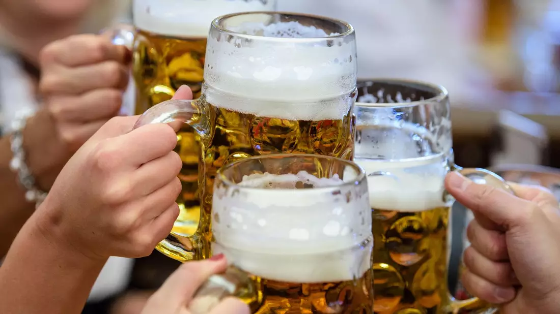 Besucherinnen prosten sich beim Auftakt zum Oktoberfest im Paulaner-Festzelt mit ihrer ersten Maß Bier zu. - Bild: Matthias Balk/dpa